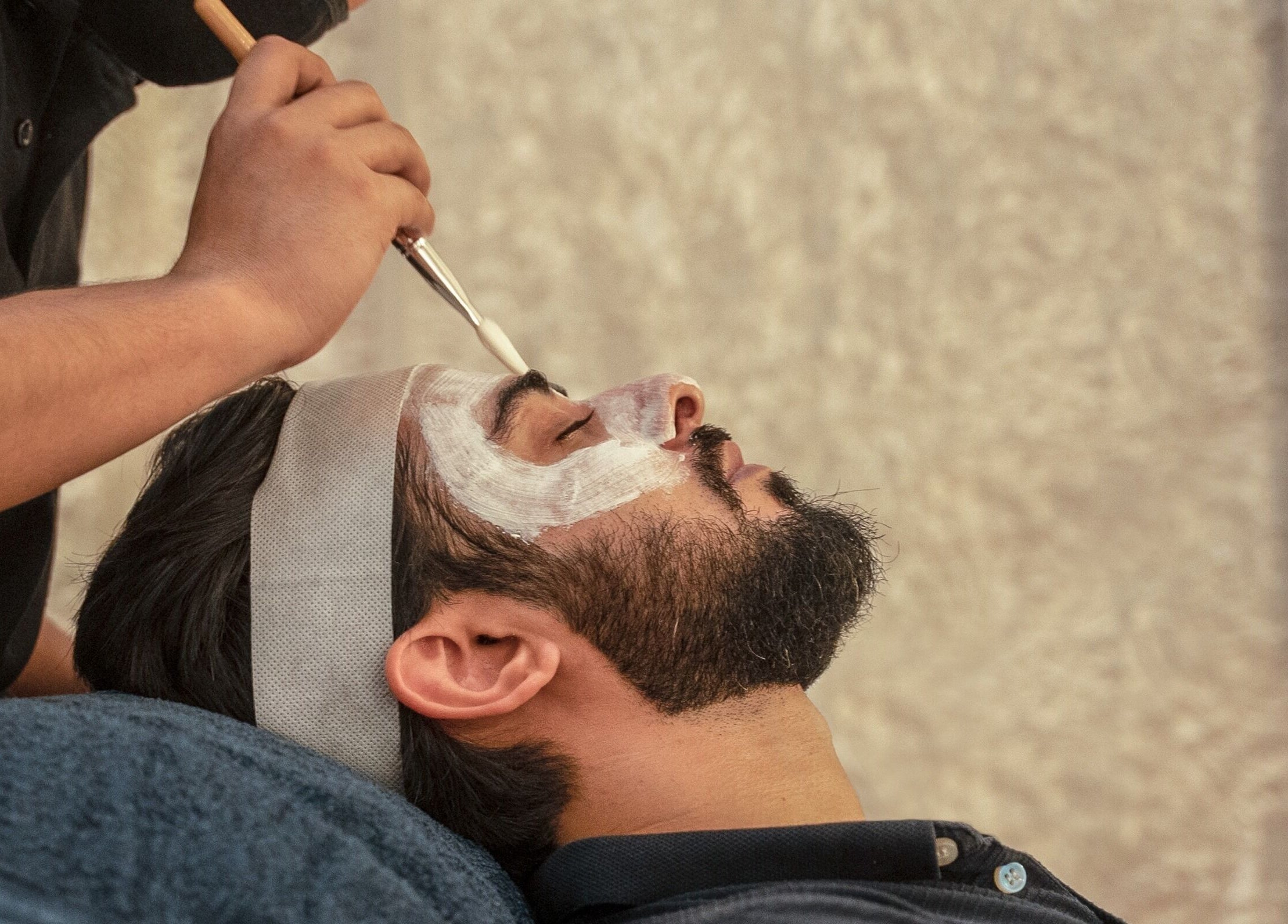 Man receiving a relaxing facial treatment at The Lair Man, Mumbai, Maharashtra, IN.