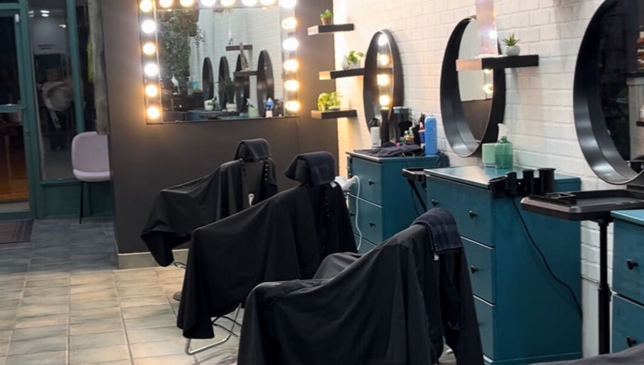 6ity Hair salon interior in Whitby, Ontario, CA with modern styling stations and illuminated mirrors.