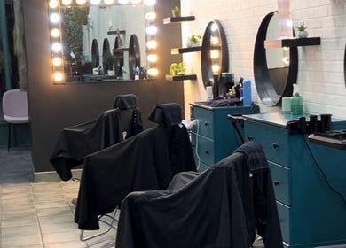 6ity Hair salon interior in Whitby, Ontario, CA with modern styling stations and illuminated mirrors.