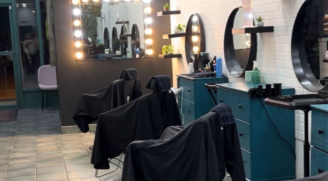 6ity Hair salon interior in Whitby, Ontario, CA with modern styling stations and illuminated mirrors.