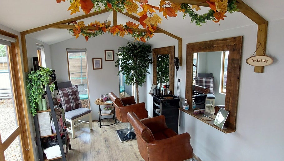 Chic interior of The Hair Lodge in Wakefield, England, GB showcasing rustic charm with leather chairs and plant decor.