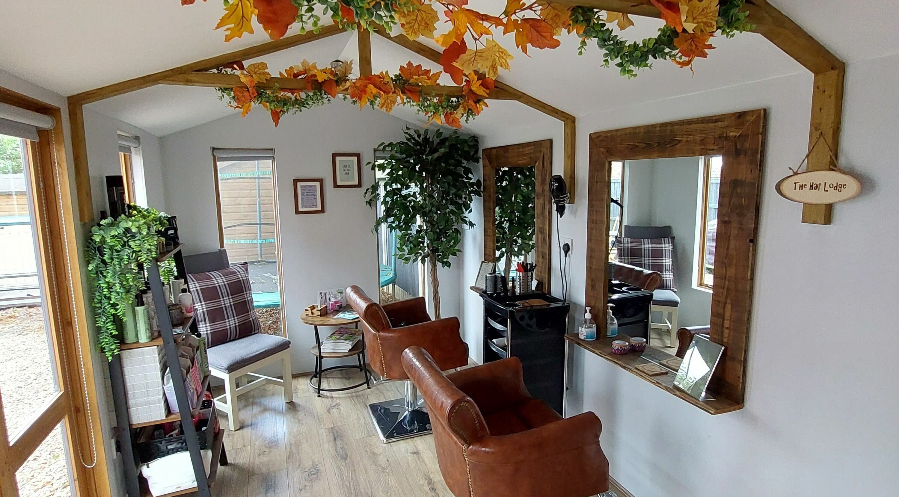 Chic interior of The Hair Lodge in Wakefield, England, GB showcasing rustic charm with leather chairs and plant decor.