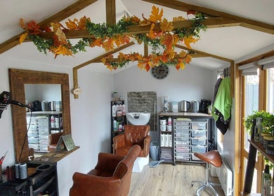 Cozy interior of The Hair Lodge in Wakefield, England, GB with autumn decor and salon chairs.