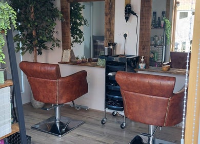 Interior of The Hair Lodge in Wakefield, England, GB, featuring elegant salon chairs and full-length mirrors.