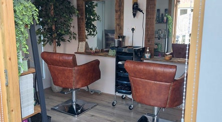 Interior of The Hair Lodge in Wakefield, England, GB, featuring elegant salon chairs and full-length mirrors.