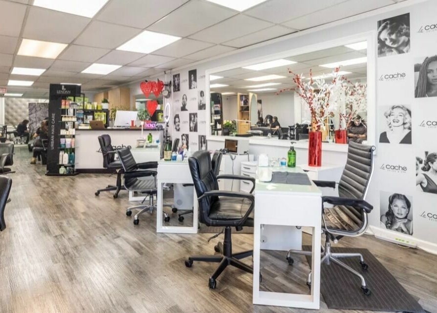 Bright interior of Le Cache Salon in Newark, New Jersey, showcasing modern styling stations and decor.