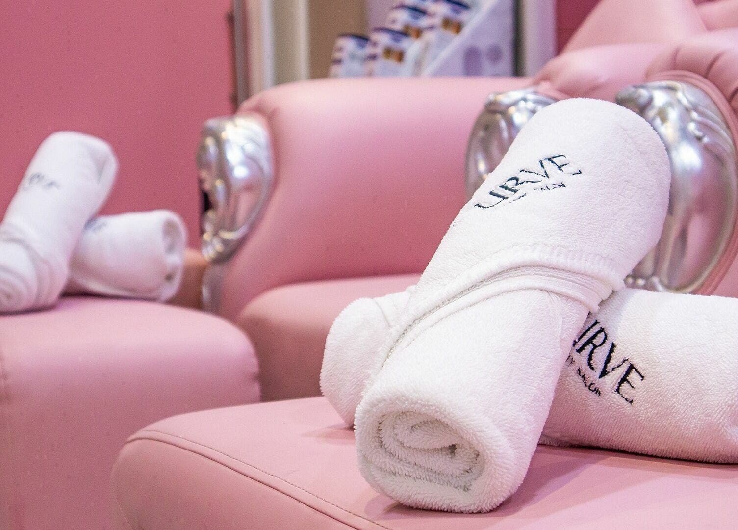 Luxurious pink seating with branded towels at Curve Beauty Salon, Dubai, Dubai, AE.