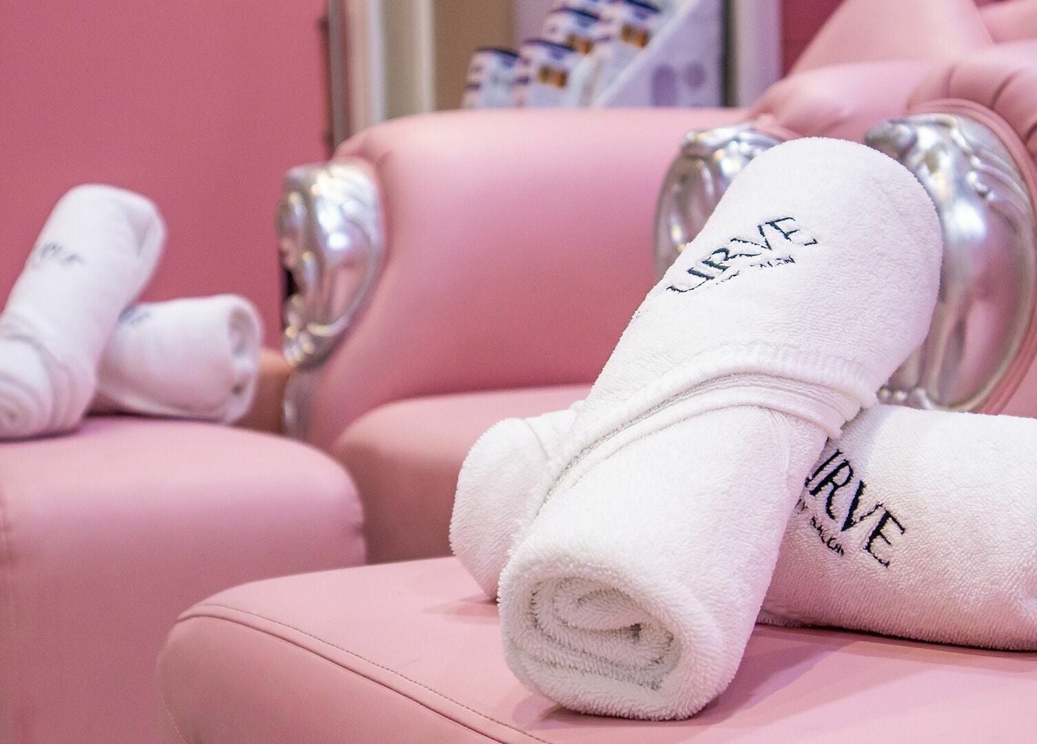 Luxurious pink seating with branded towels at Curve Beauty Salon, Dubai, Dubai, AE.