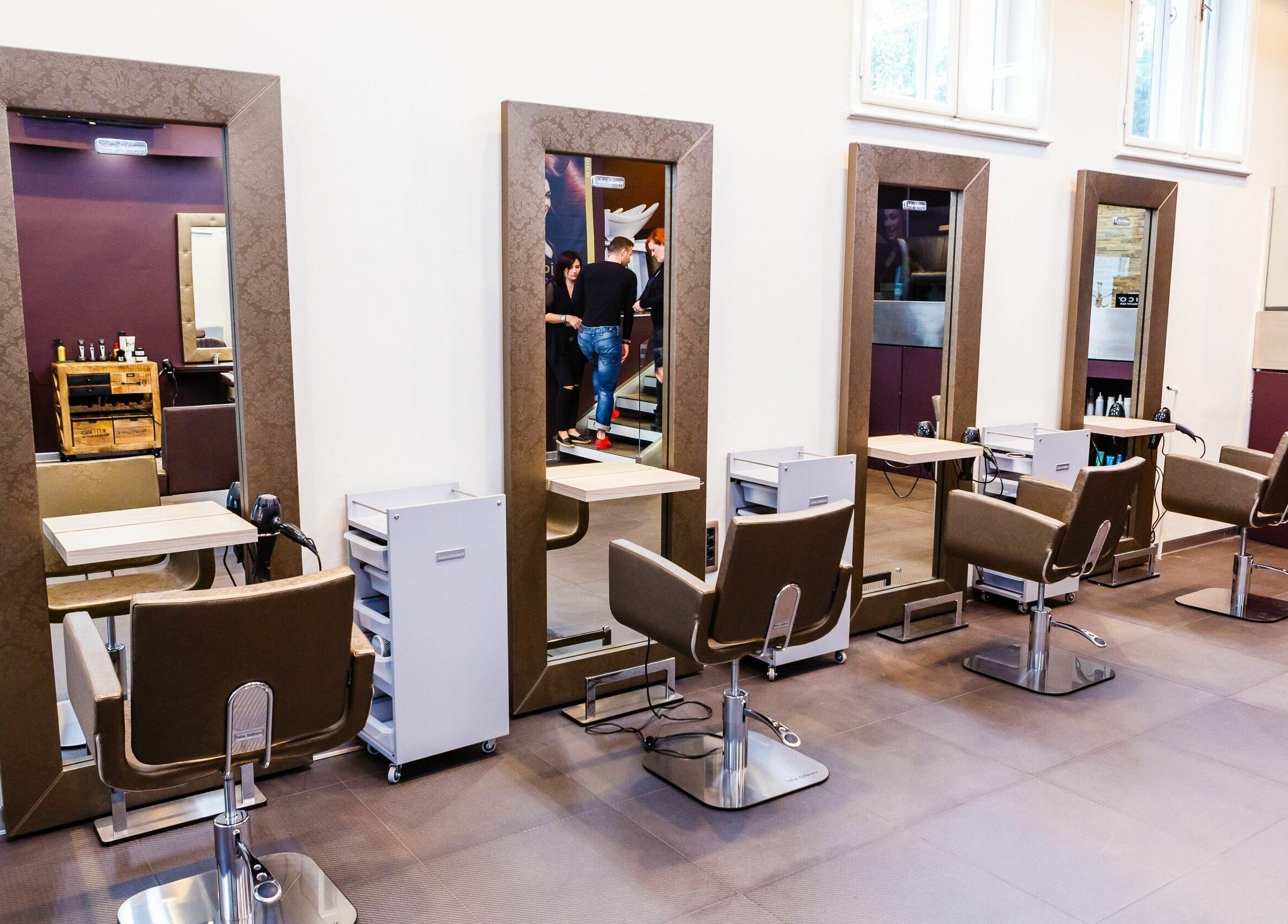 Notranjost sodobnega Tjasha Frizersko Brivski Salon Center v Ljubljani, Ljubljana, SI s stilskimi ogledali.