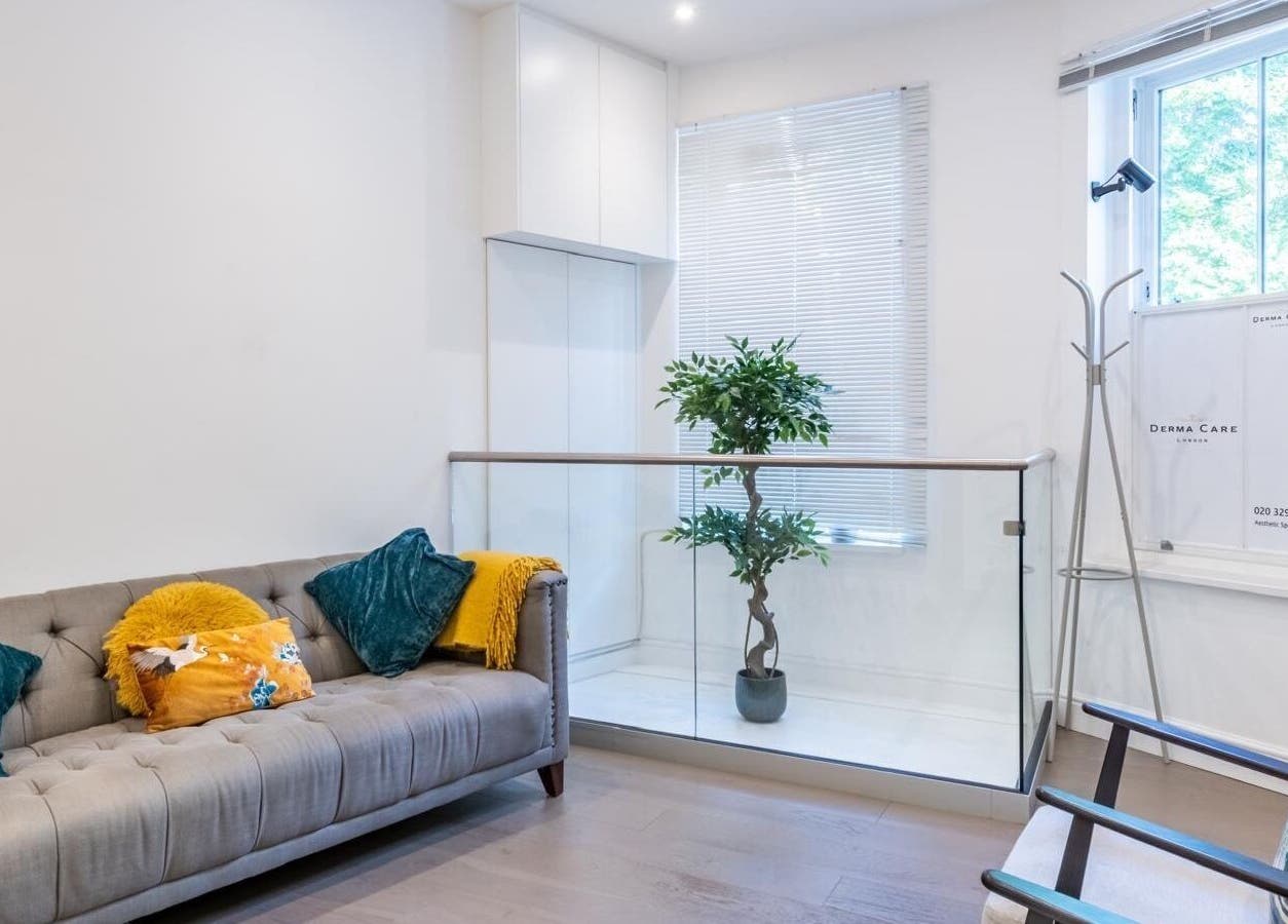 Cozy waiting area at Waxing London Pro - Battersea, London, England, GB with a plush sofa and stylish decor.