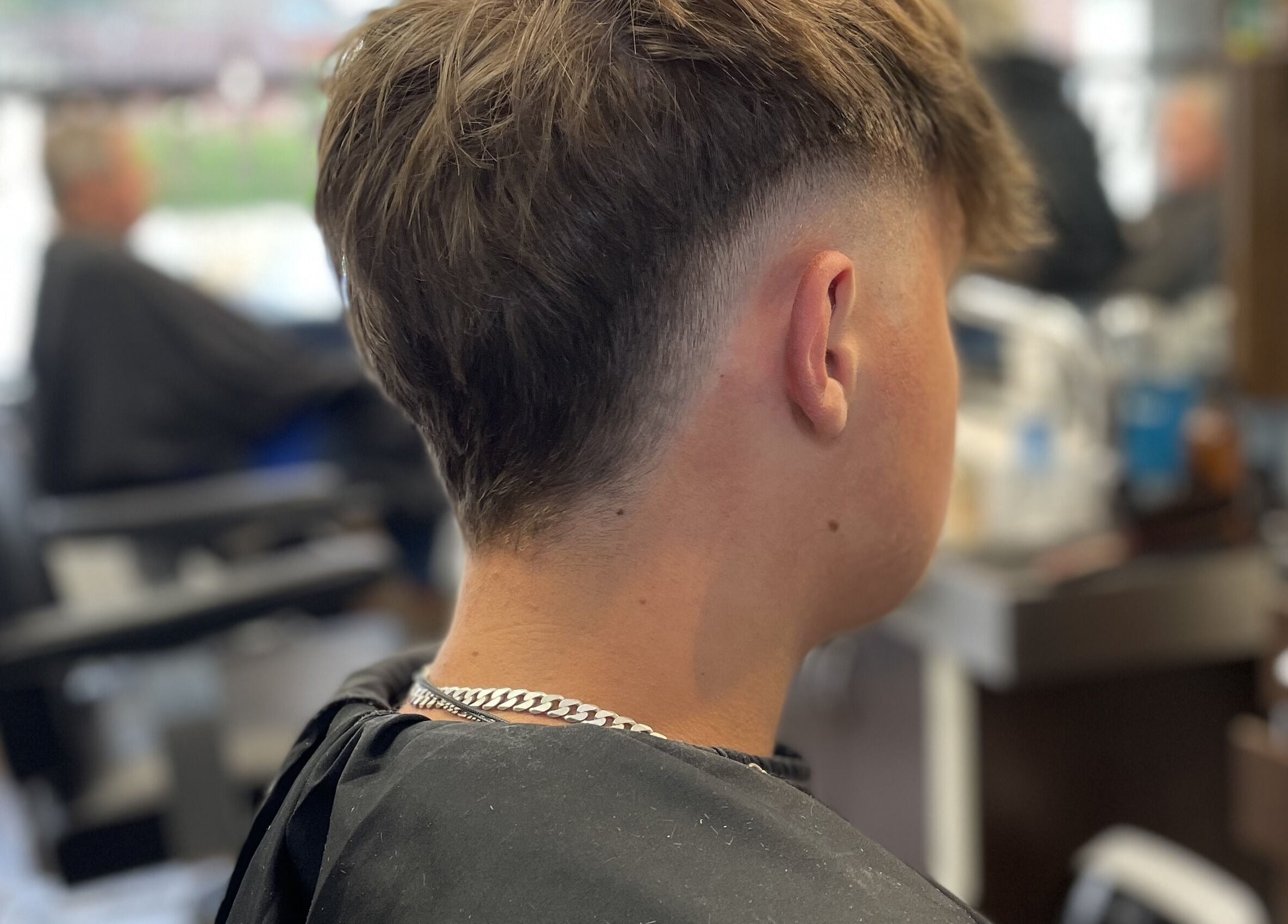 Close-up of a modern haircut at Wild's Barbershop, Sheffield, England, GB, showcasing a stylish fade.
