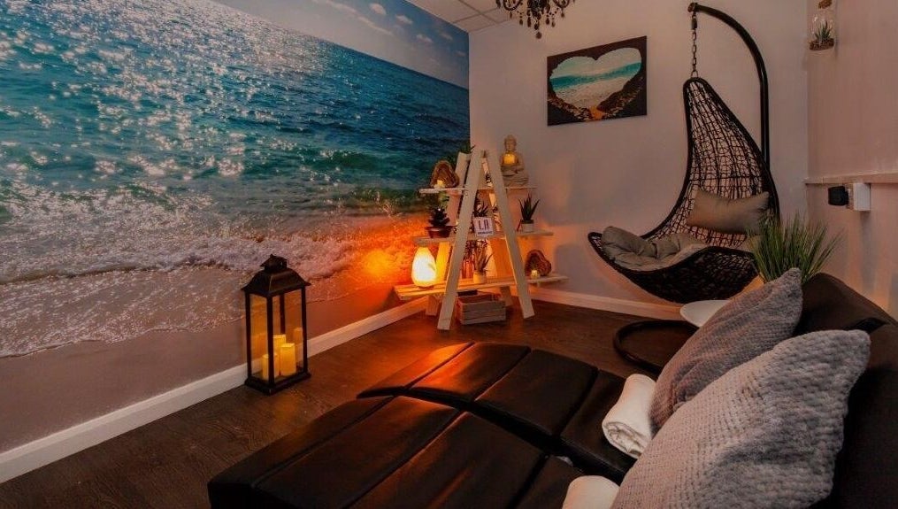 Relaxing coastal-themed room at LA Beauty and Spa in Aston, England, GB with cozy chairs and beach mural.