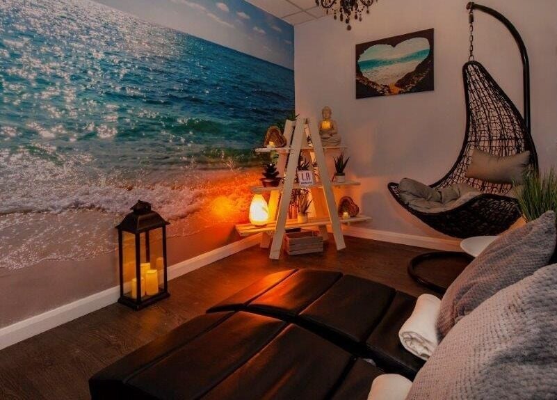 Relaxing coastal-themed room at LA Beauty and Spa in Aston, England, GB with cozy chairs and beach mural.
