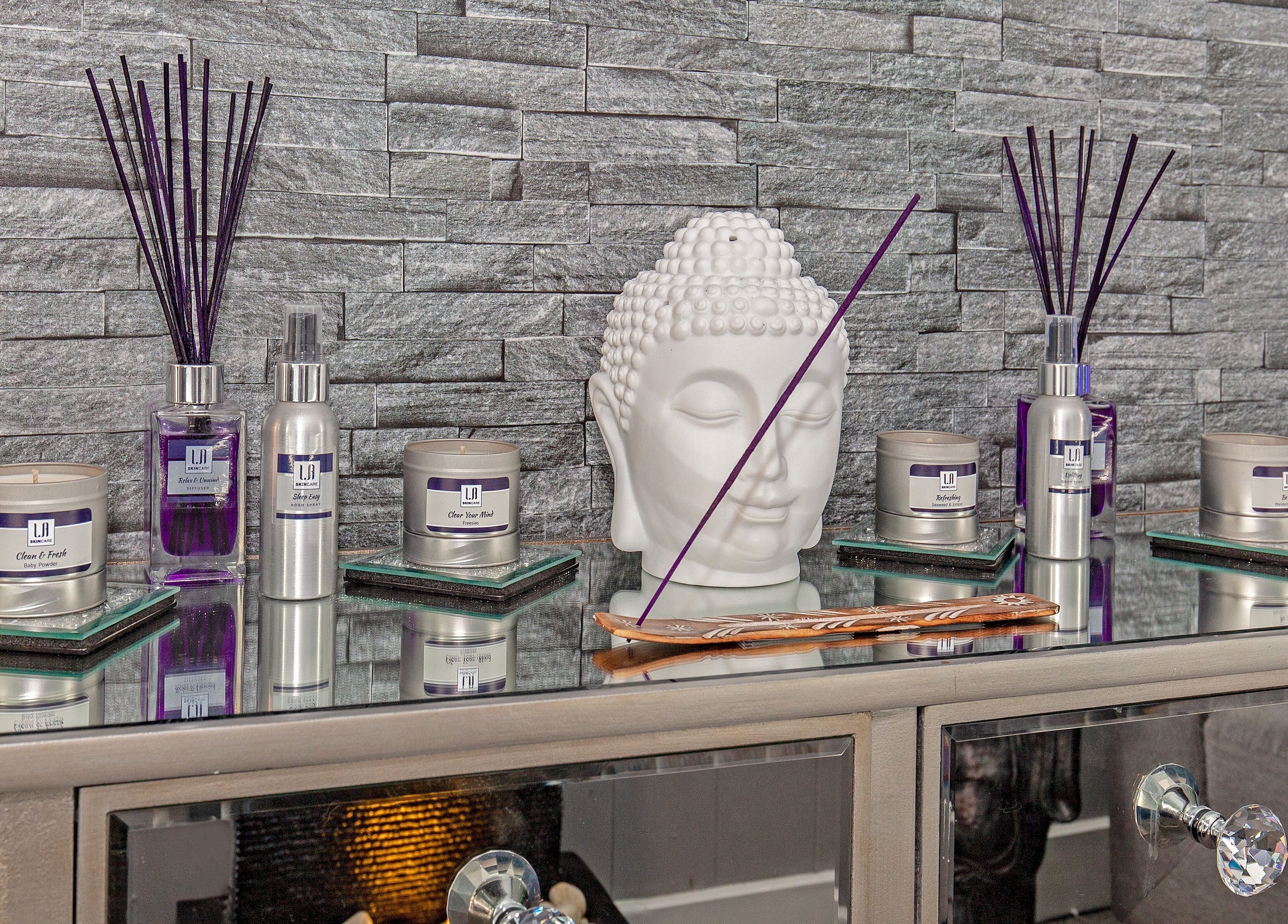 Elegant spa products at LA Beauty and Spa, Aston, England, GB enhance tranquil ambiance with Buddha statue.