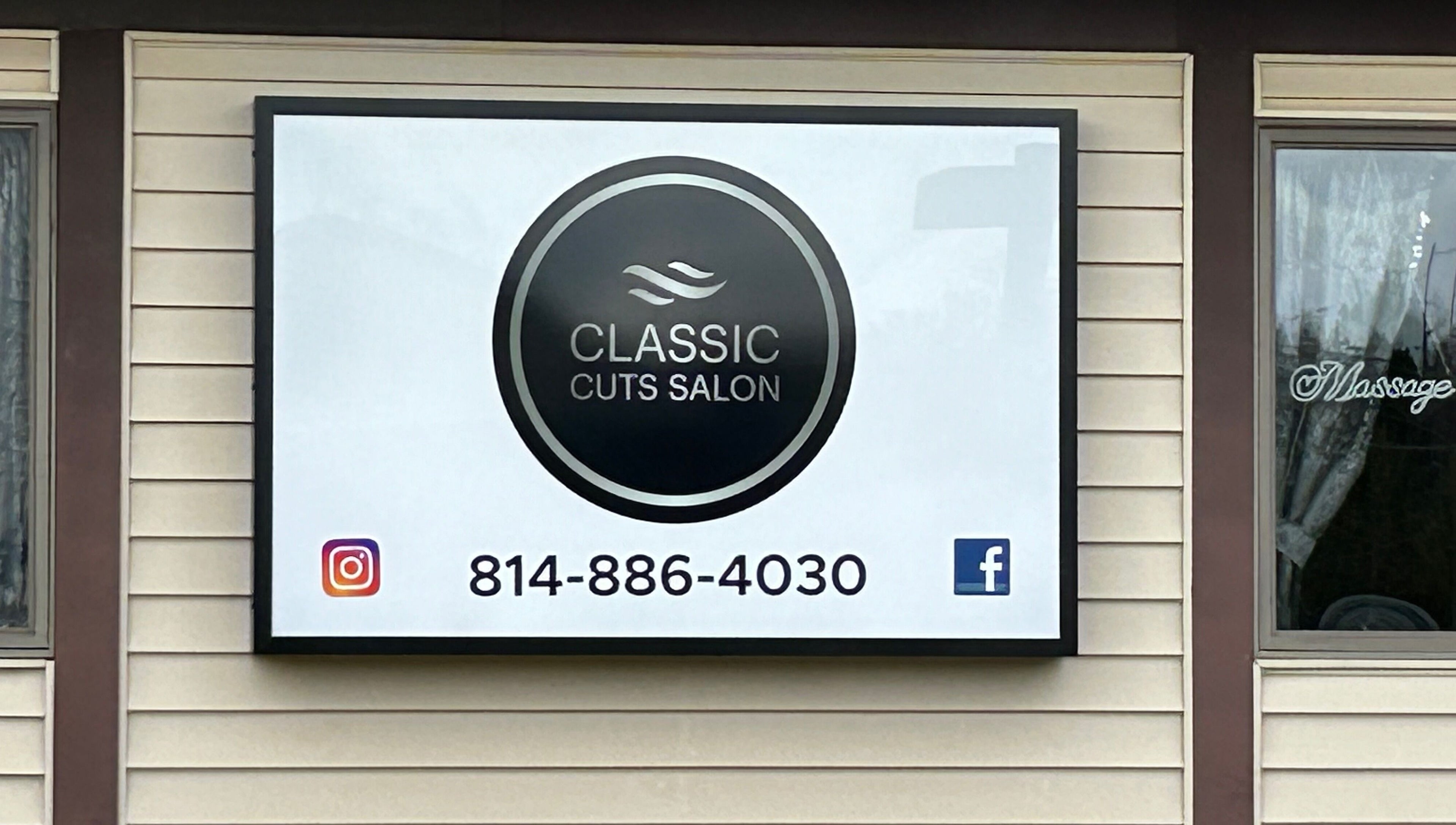 Classic Cuts Salon signboard in Cresson, Pennsylvania, US, displaying contact details and social media logos.