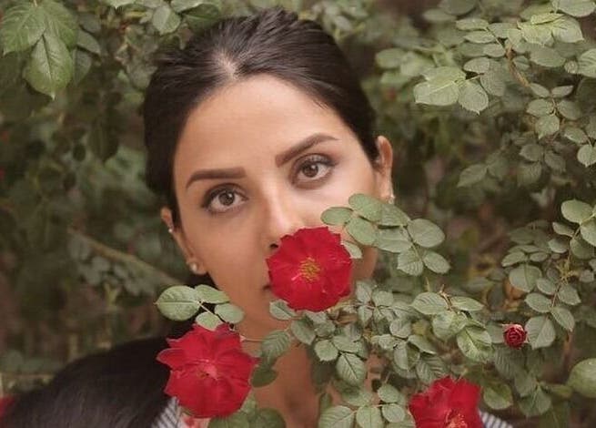 Woman with roses at Shivilashes, Coquitlam, British Columbia, CA. Captivating beauty among vibrant blooms.