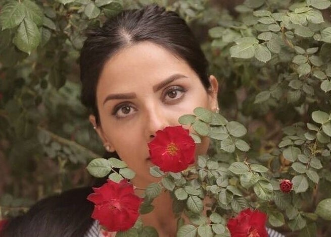 Woman with roses at Shivilashes, Coquitlam, British Columbia, CA. Captivating beauty among vibrant blooms.