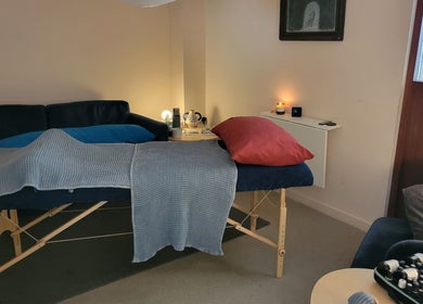 Cozy massage room at AmberLuna Apothecary in Bristol, England, GB, with soft lighting and a plush massage table.