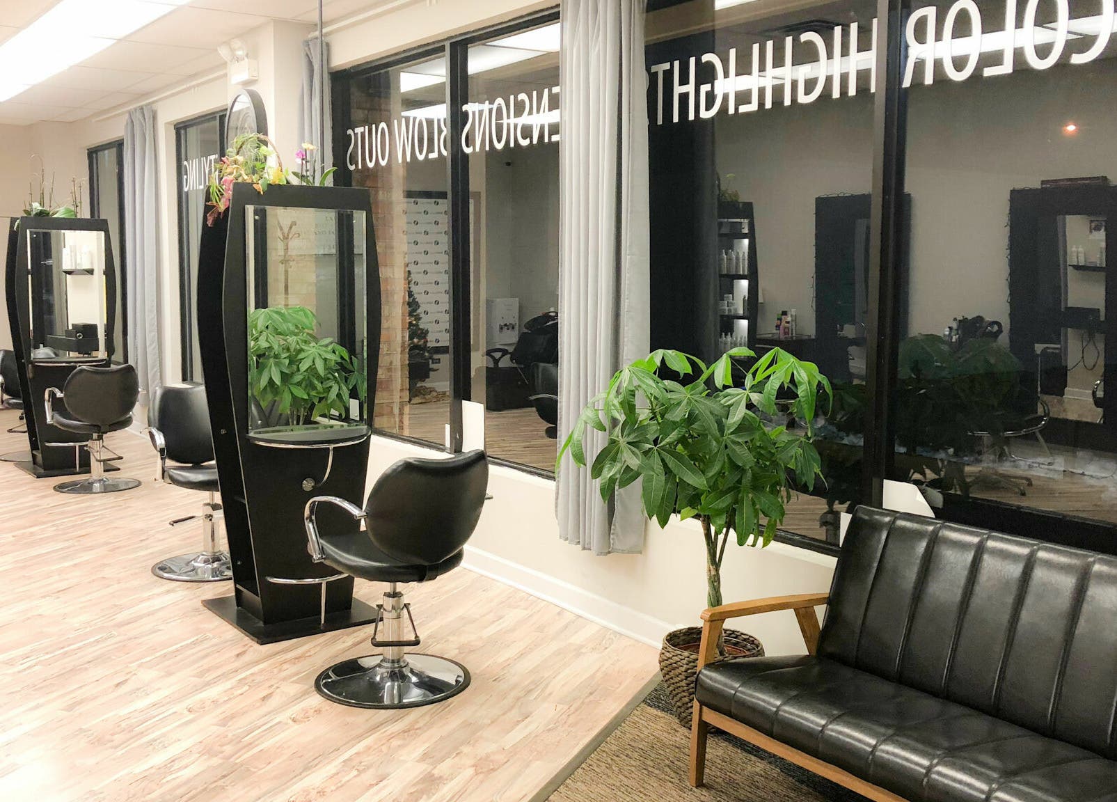 Stylish interior of Surge Salon in Glen Ellyn, Illinois, US, with modern stations and lush plants.