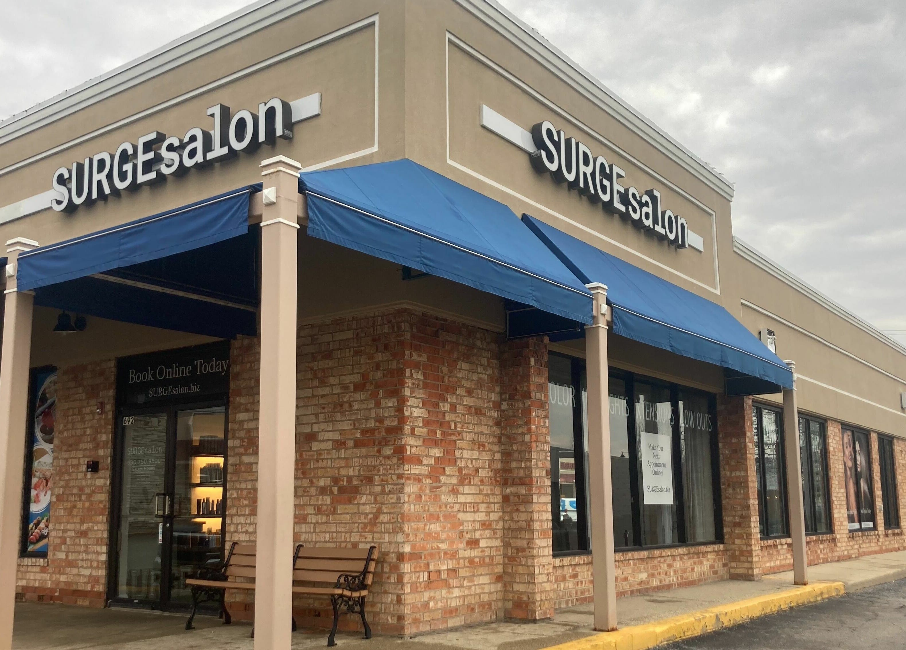 Exterior view of Surge Salon in Glen Ellyn, Illinois, US with a blue awning and inviting entrance.