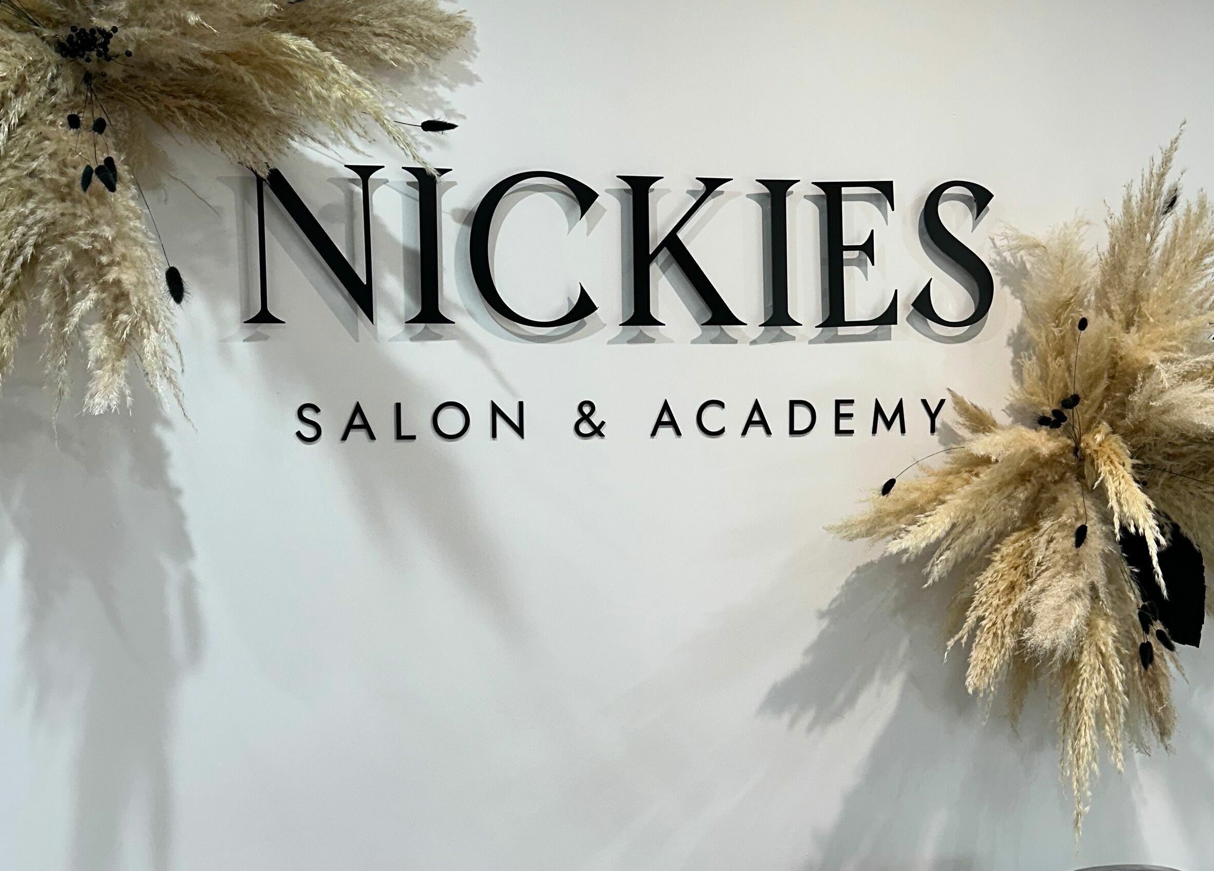 Entrance sign of Nickies Salon & Academy, Musselburgh, Scotland, GB with decorative pampas grass.