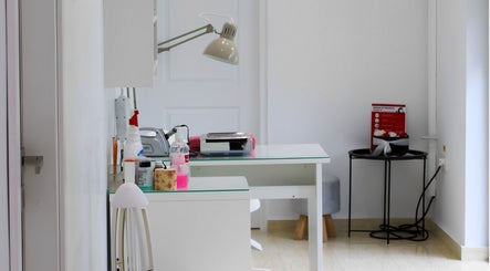 Interior minimalist al Noia Copou, Iași, România RO, cu masă albă și lămpi moderne.