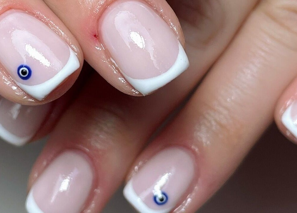 French manicure with blue evil eye nail art at Beautology Newcastle, Whitley Bay, England, GB.