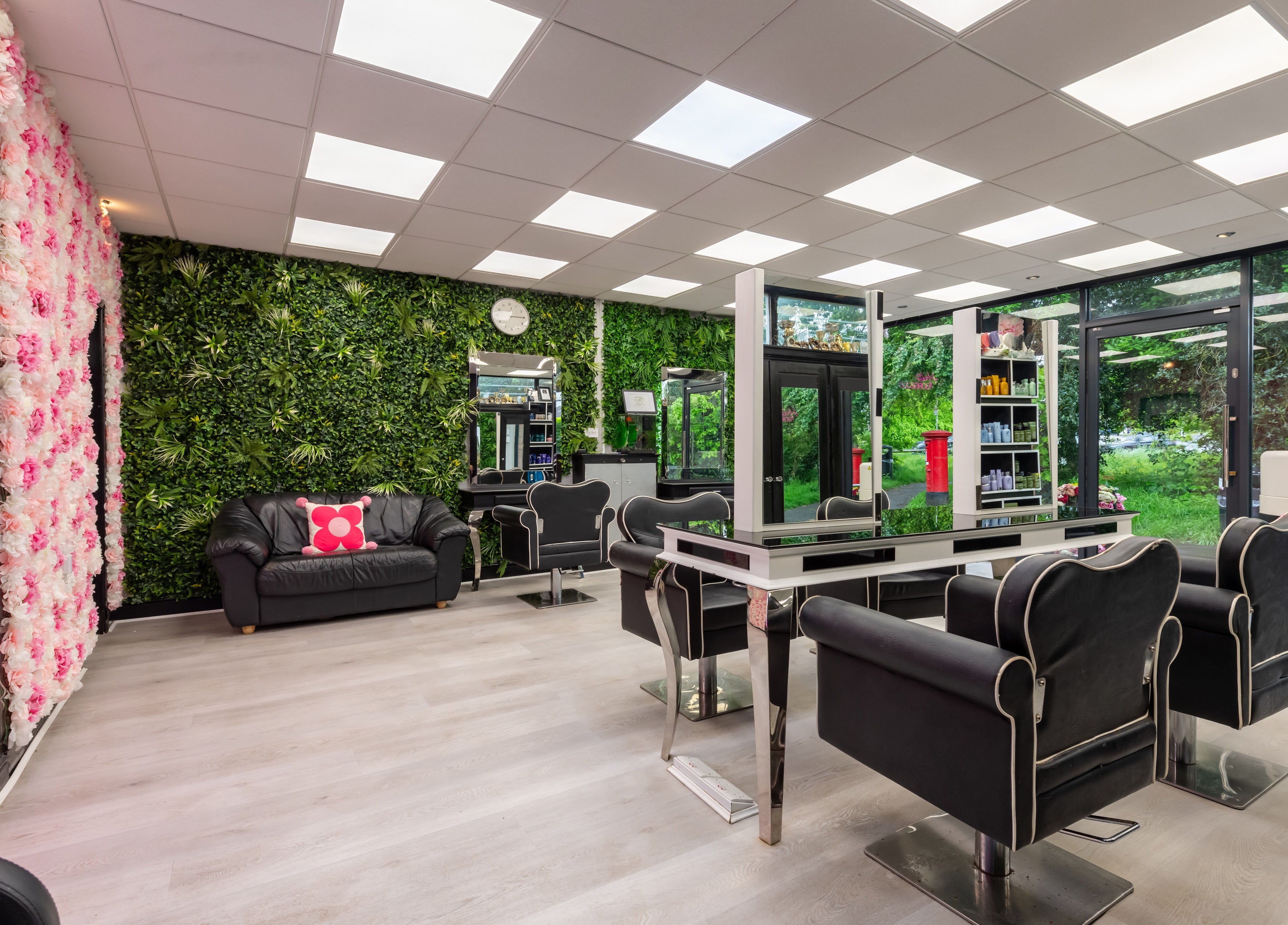 Stylish interior of Chop and Change salon in Addlestone, England, GB featuring lush greenery and modern seating.