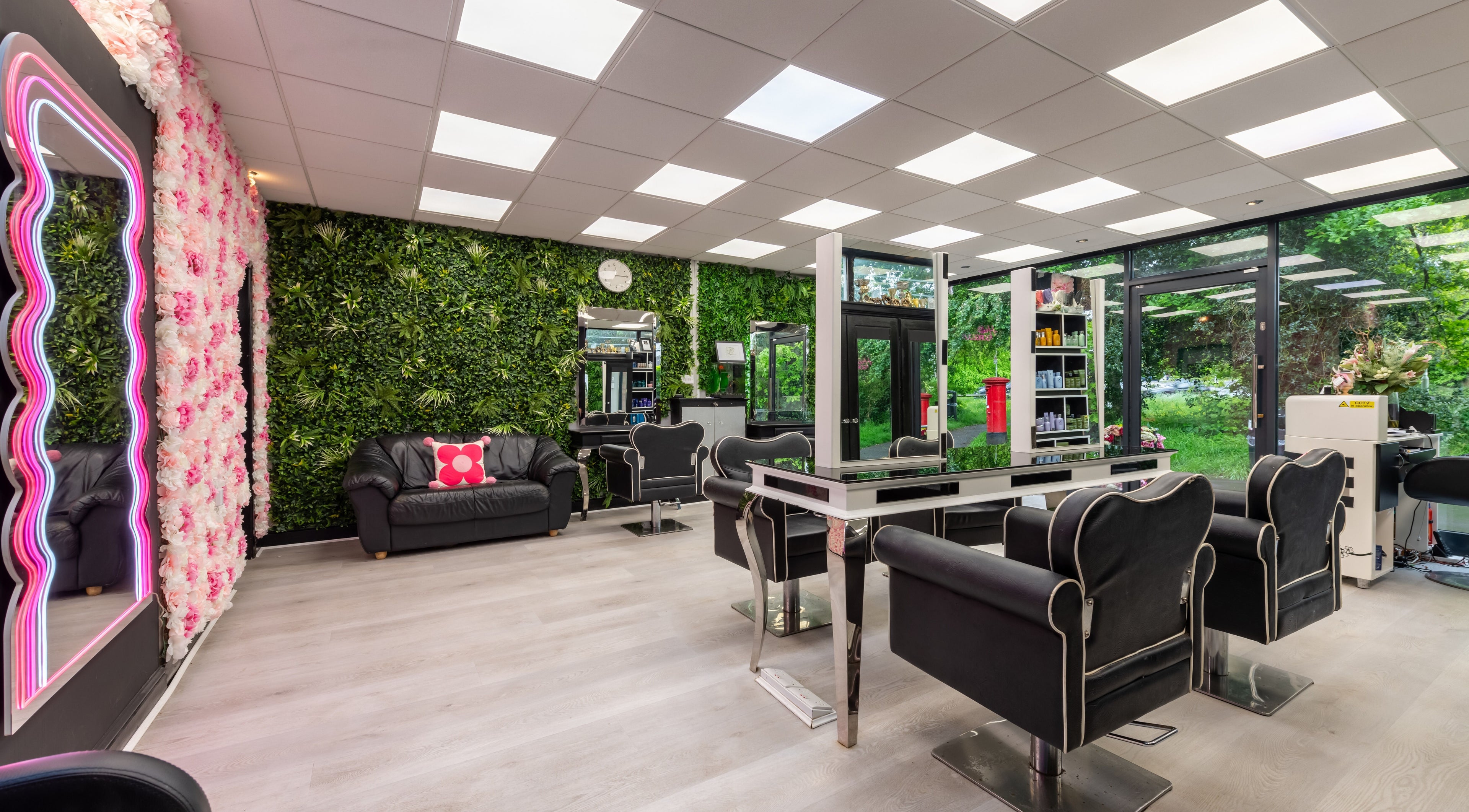 Stylish interior of Chop and Change salon in Addlestone, England, GB featuring lush greenery and modern seating.