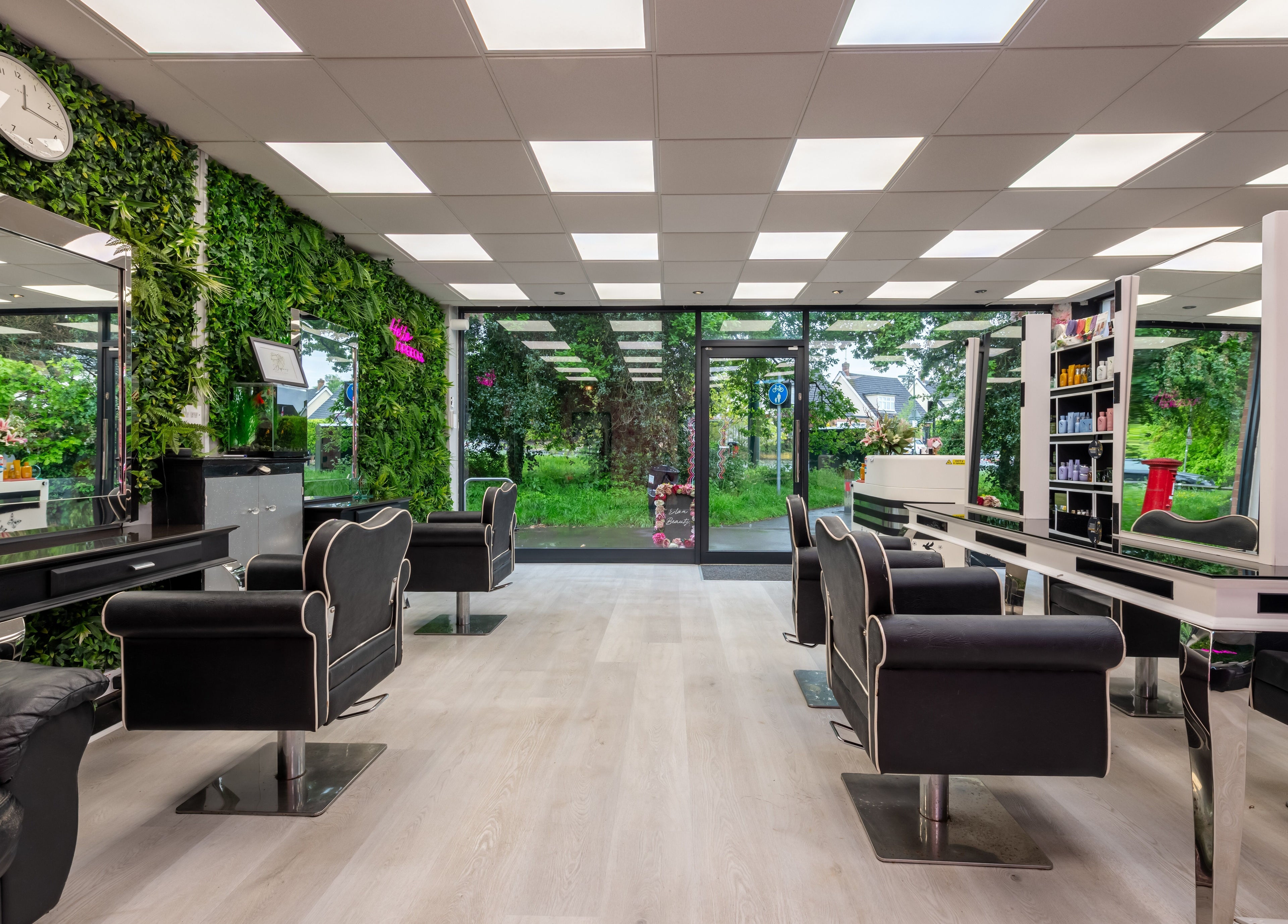 Chop and Change in Addlestone, England, GB, features a chic salon interior with lush greenery walls.