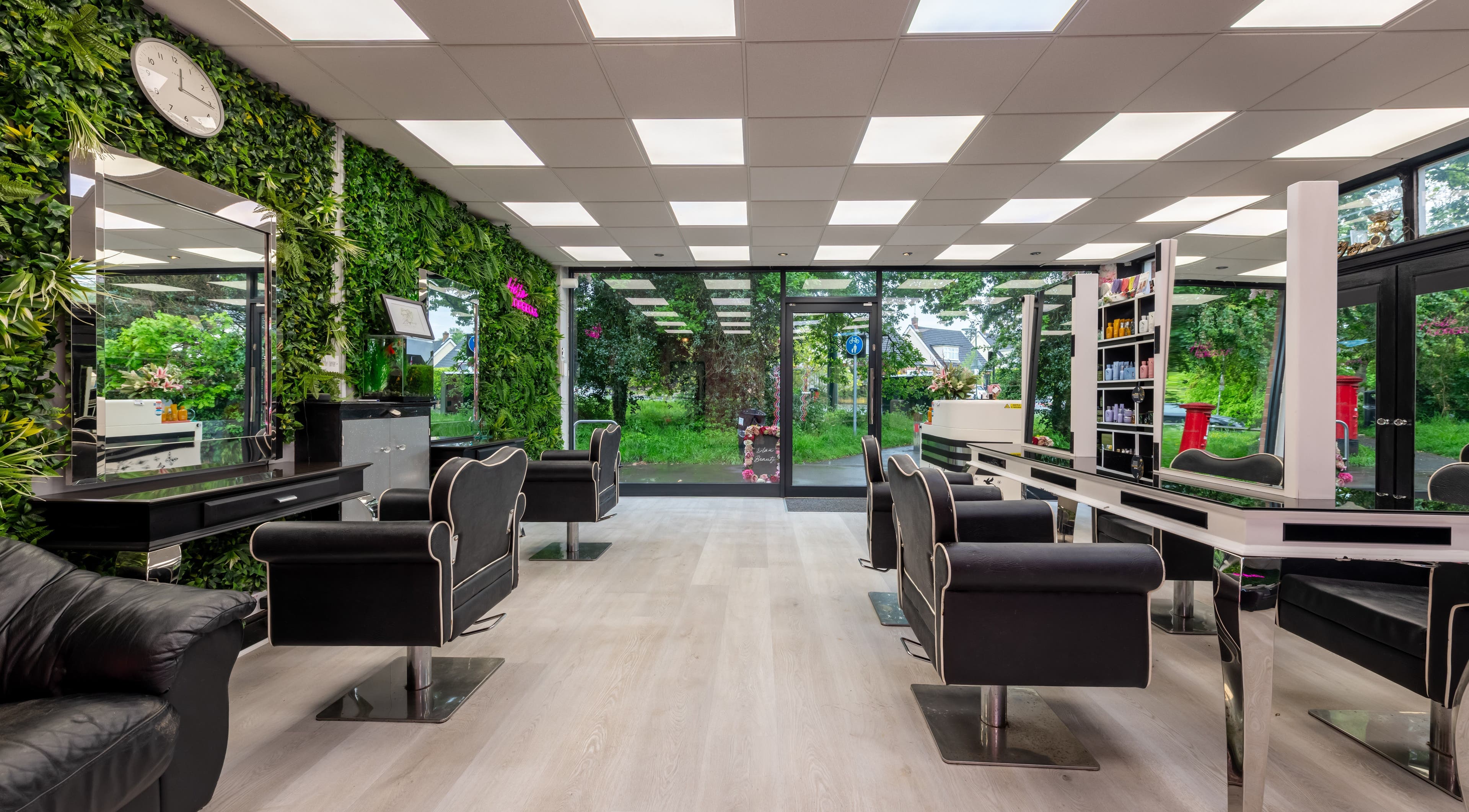 Chop and Change in Addlestone, England, GB, features a chic salon interior with lush greenery walls.