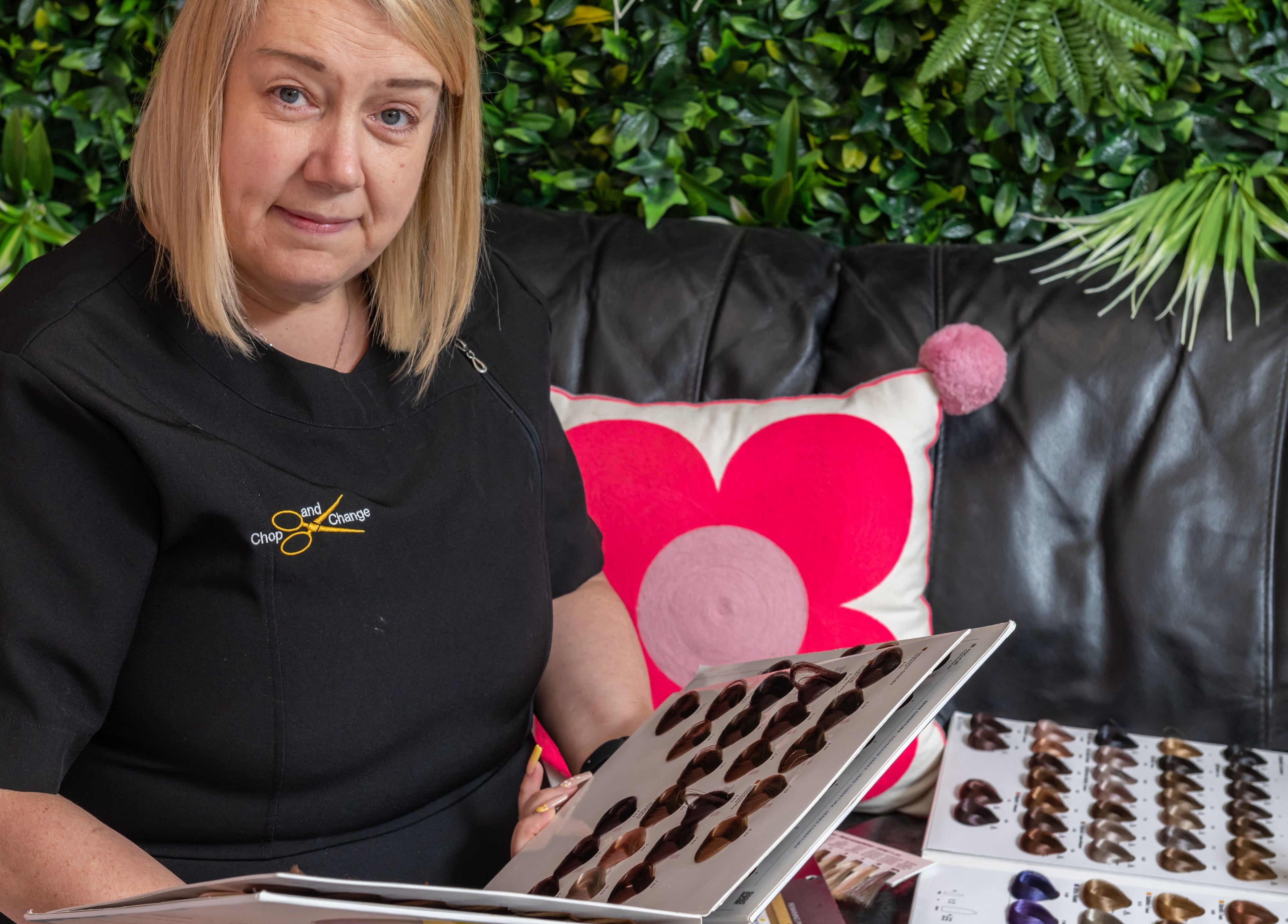 Hair stylist at Chop and Change in Addlestone, England reviews color swatches with client.