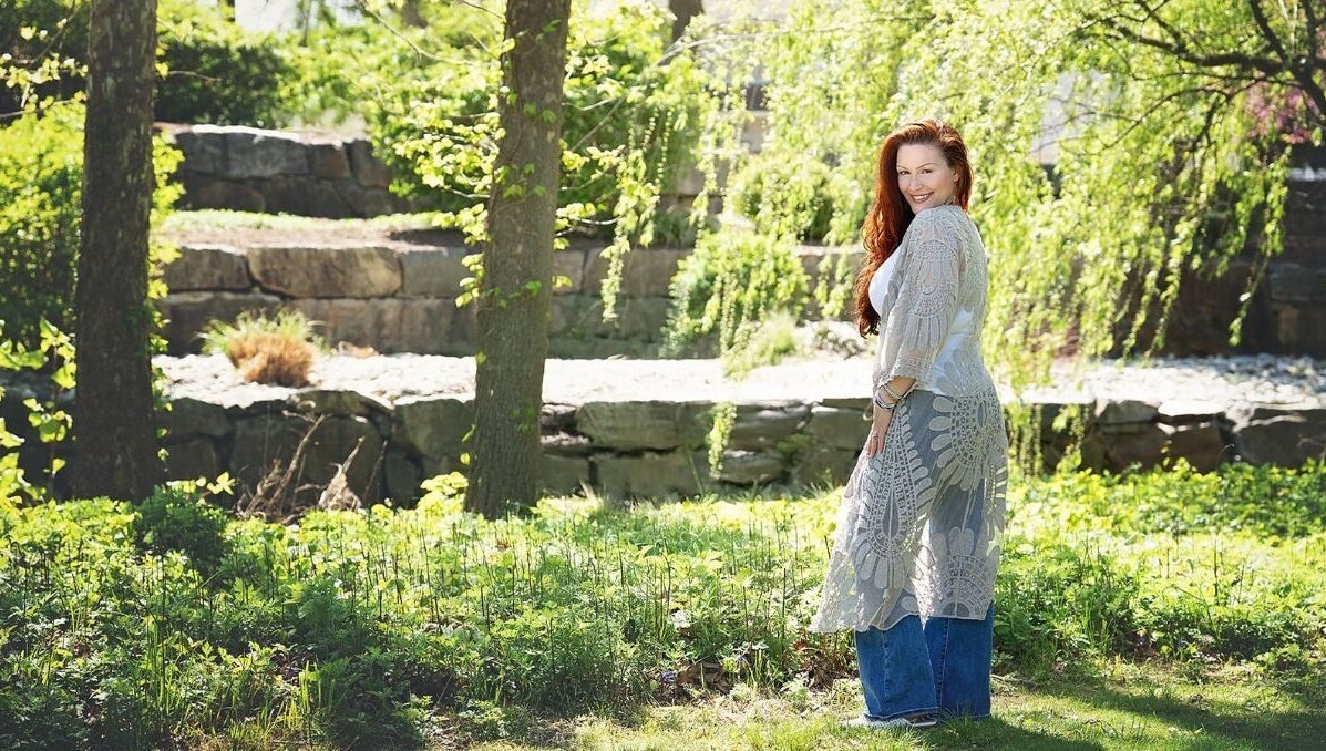 Woman in lace shawl in garden at Readings By Danielle, Hawthorne, New Jersey, US, surrounded by greenery.