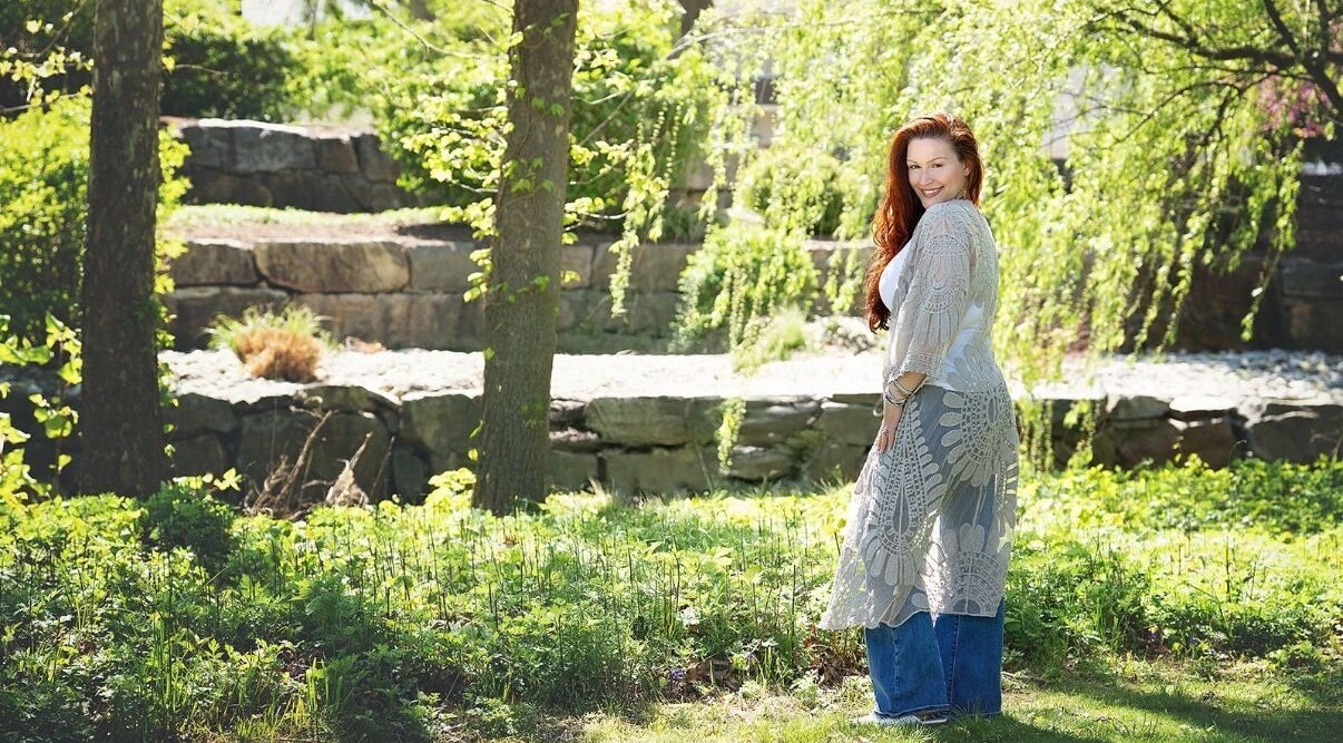 Woman in lace shawl in garden at Readings By Danielle, Hawthorne, New Jersey, US, surrounded by greenery.