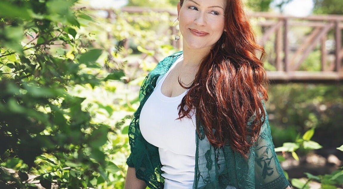 Woman enjoys nature at Readings By Danielle, Hawthorne, New Jersey, US, surrounded by lush greenery.