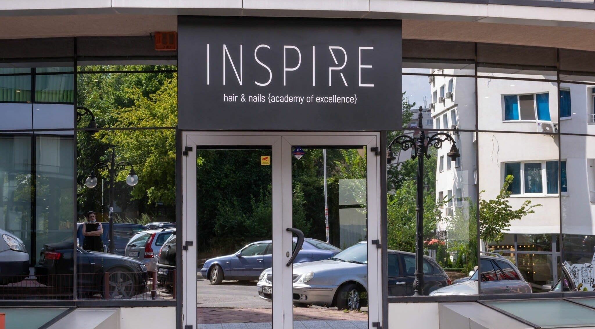 Entrance of Salon Inspire, kv. Studentski Grad, София, BG, showcasing modern glass exterior design.