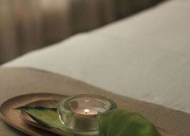 Relaxing setup at Wellness Club @ Vilalara Grand Hotel, Lagoa, Faro, PT with a candle and leaf on a tray.