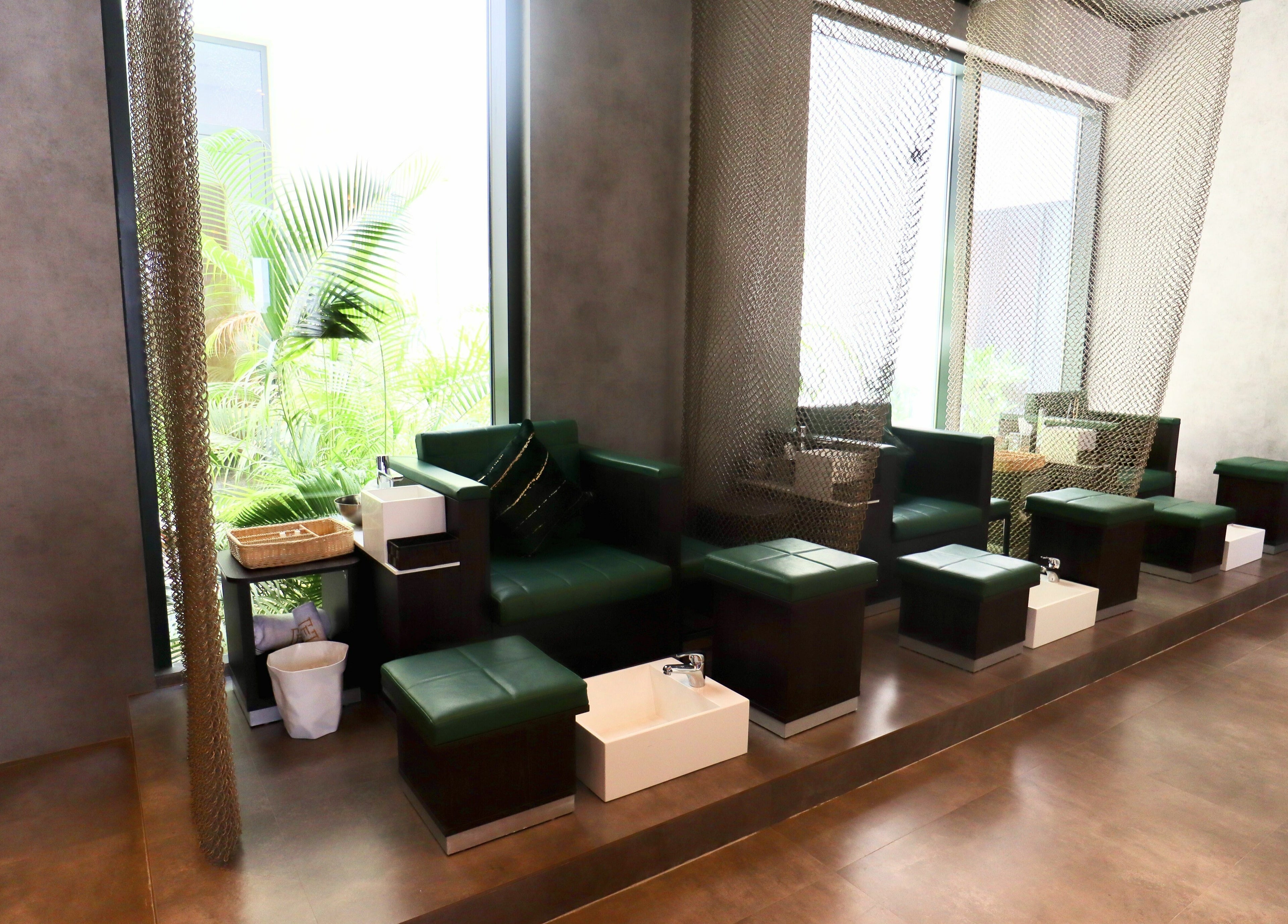 Luxurious pedicure stations at House of Fade, Dubai, AE, offering relaxation with green seating and natural light.