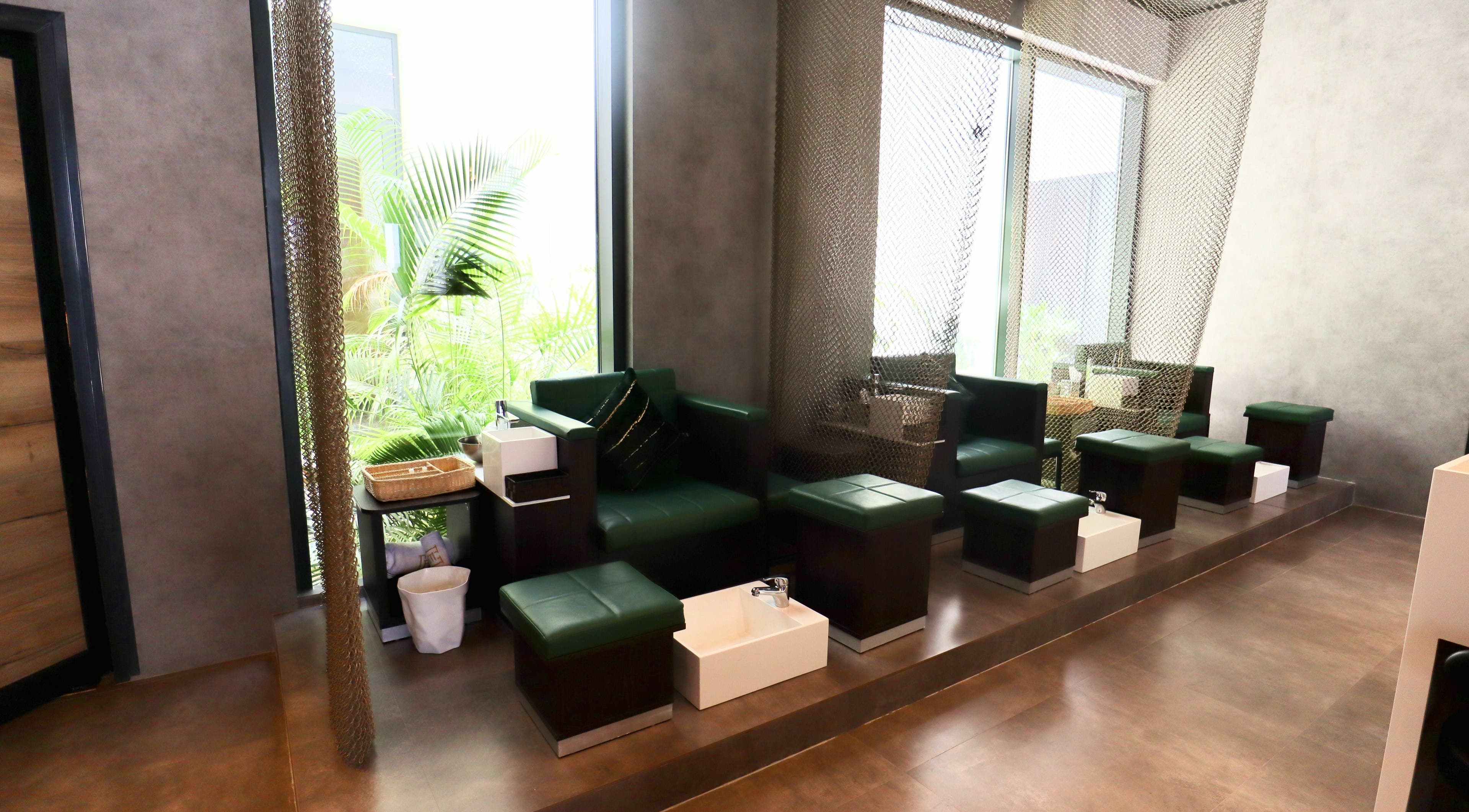 Luxurious pedicure stations at House of Fade, Dubai, AE, offering relaxation with green seating and natural light.