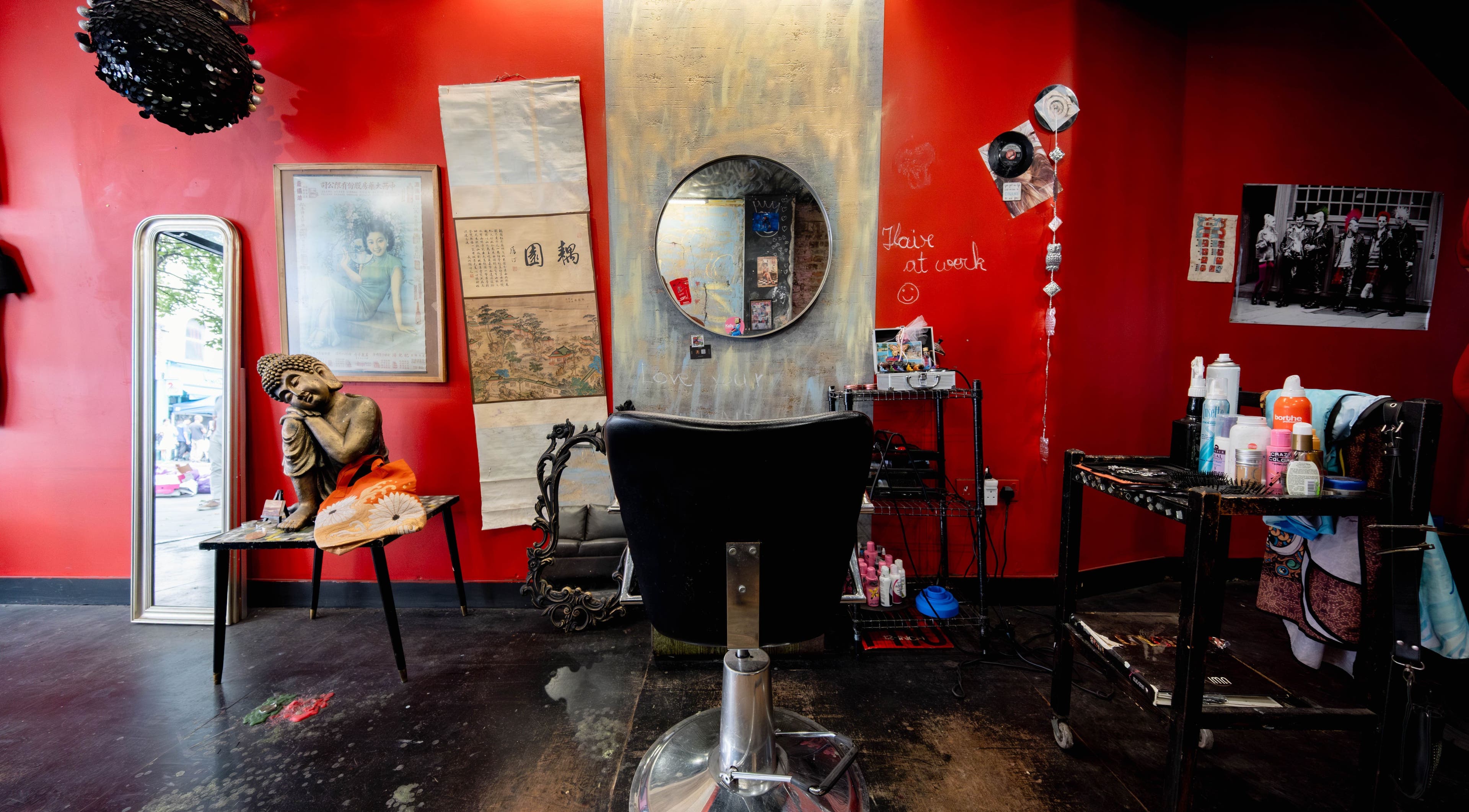 Eclectic salon interior with vibrant red walls at Unparalleled 145, London, England, GB, offering a unique ambiance.