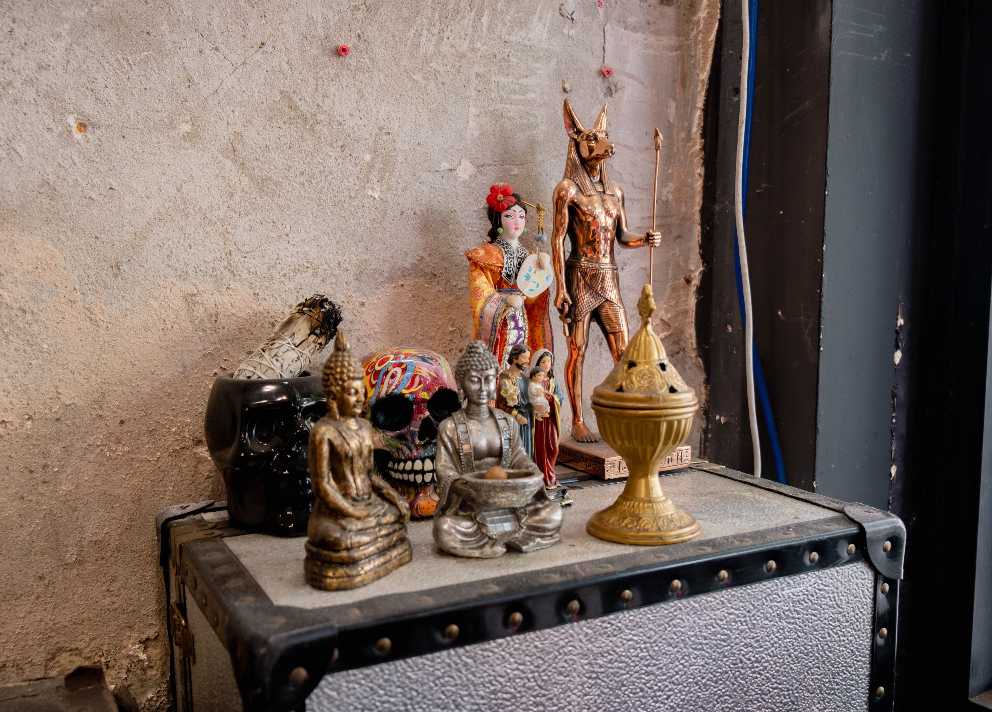 Eclectic statues adorn a shelf at Unparalleled 145, London, England, GB, creating an inspiring ambiance.