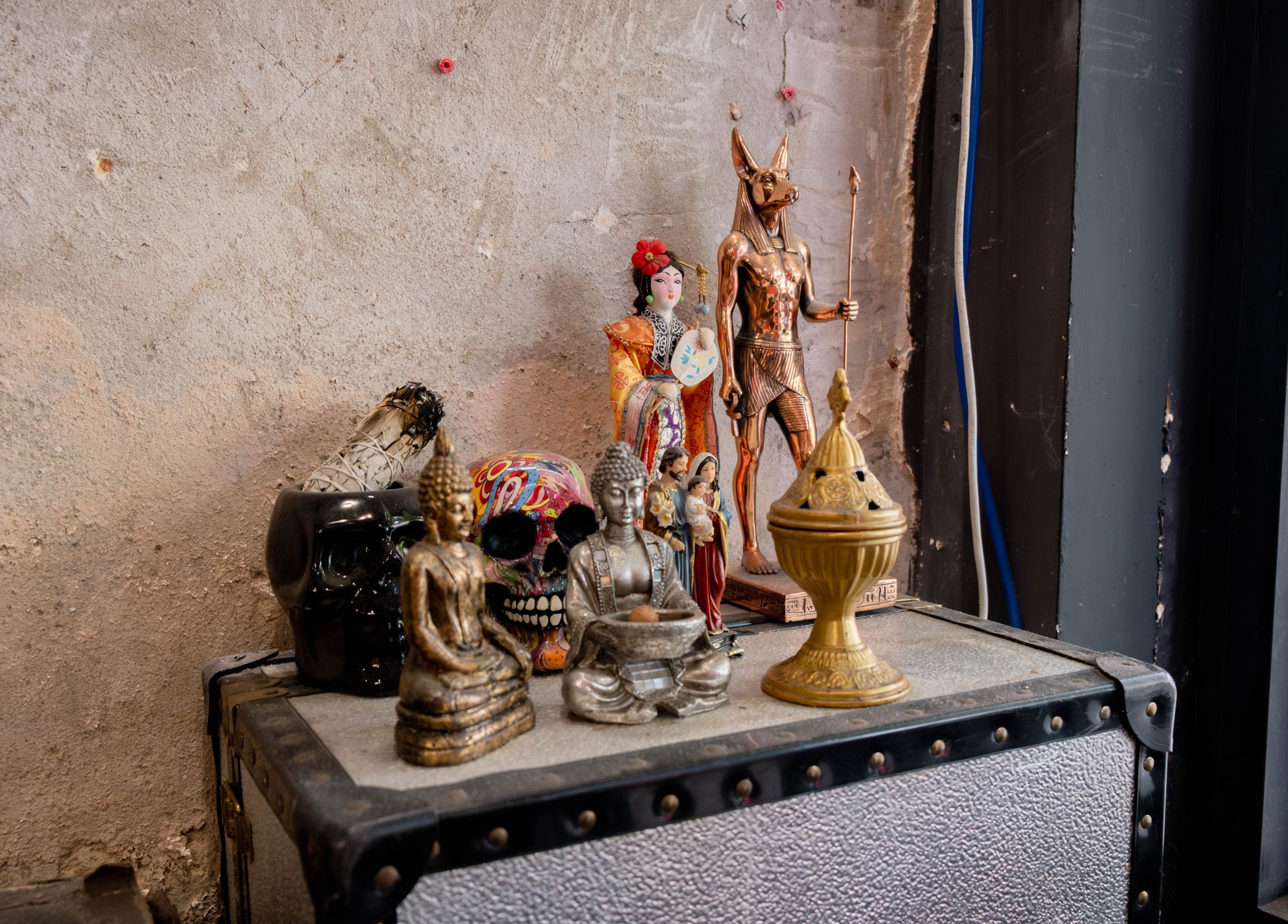 Eclectic statues adorn a shelf at Unparalleled 145, London, England, GB, creating an inspiring ambiance.