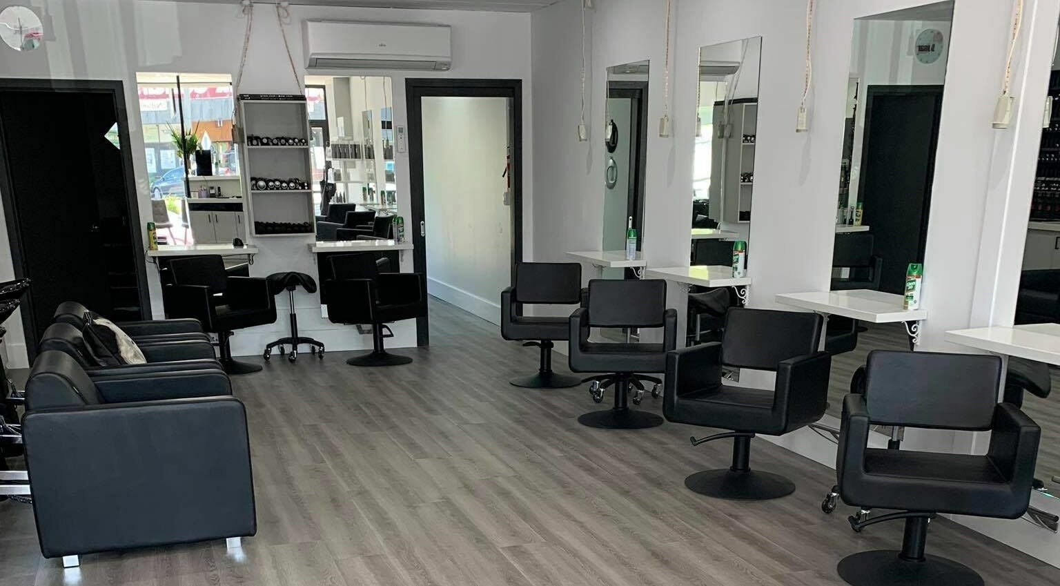 Modern salon at Jonar Hair, Diamond Creek, Victoria, AU with sleek black chairs and mirrors.