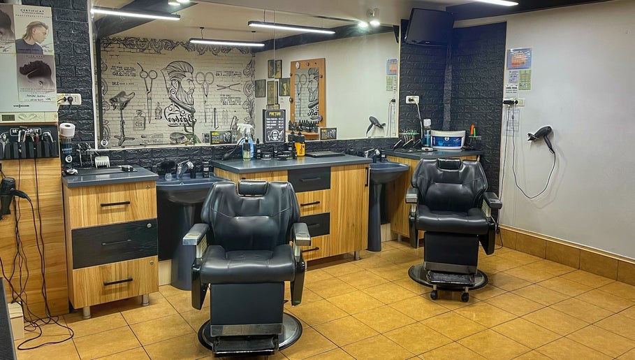 Interior modern al Frizeria Domenii, București, București, RO, cu scaune elegante și decor contemporan.