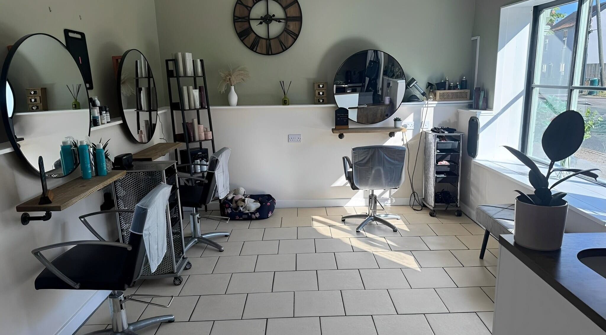 Interior of Hair’ology salon in East Harling, England, GB showcasing modern styling stations and bright decor.