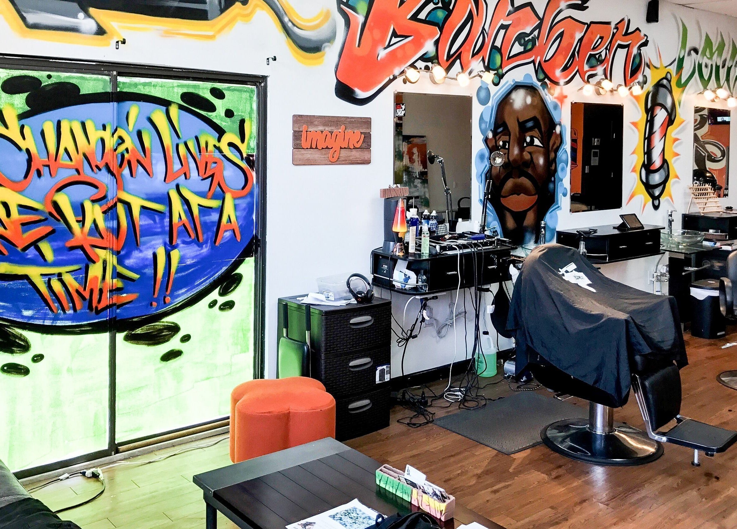 Inside Perfect Blendz Barber Lounge, Jonesboro, Georgia, with vibrant graffiti art and modern barber chairs.