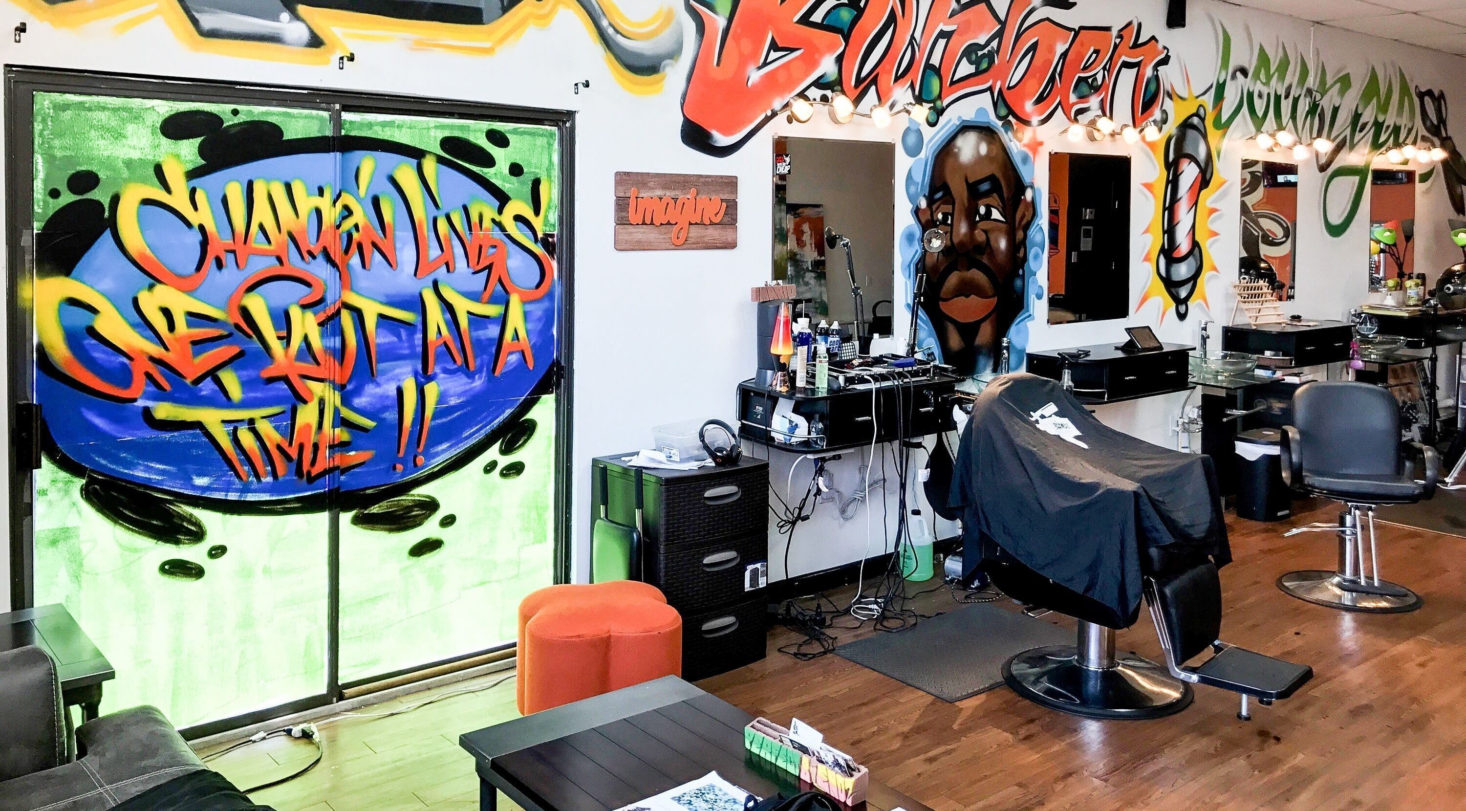 Inside Perfect Blendz Barber Lounge, Jonesboro, Georgia, with vibrant graffiti art and modern barber chairs.