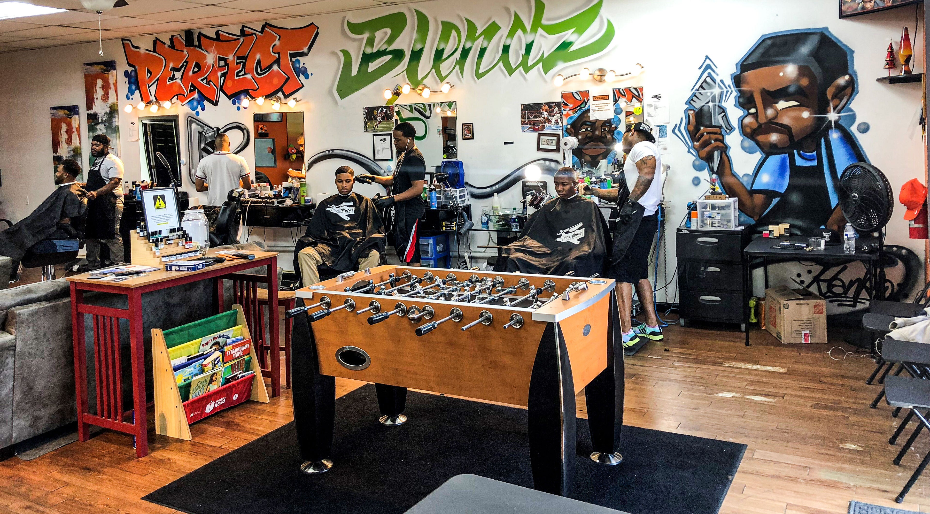 Interior of Perfect Blendz Barber Lounge in Jonesboro, Georgia, US with vibrant murals and foosball table.