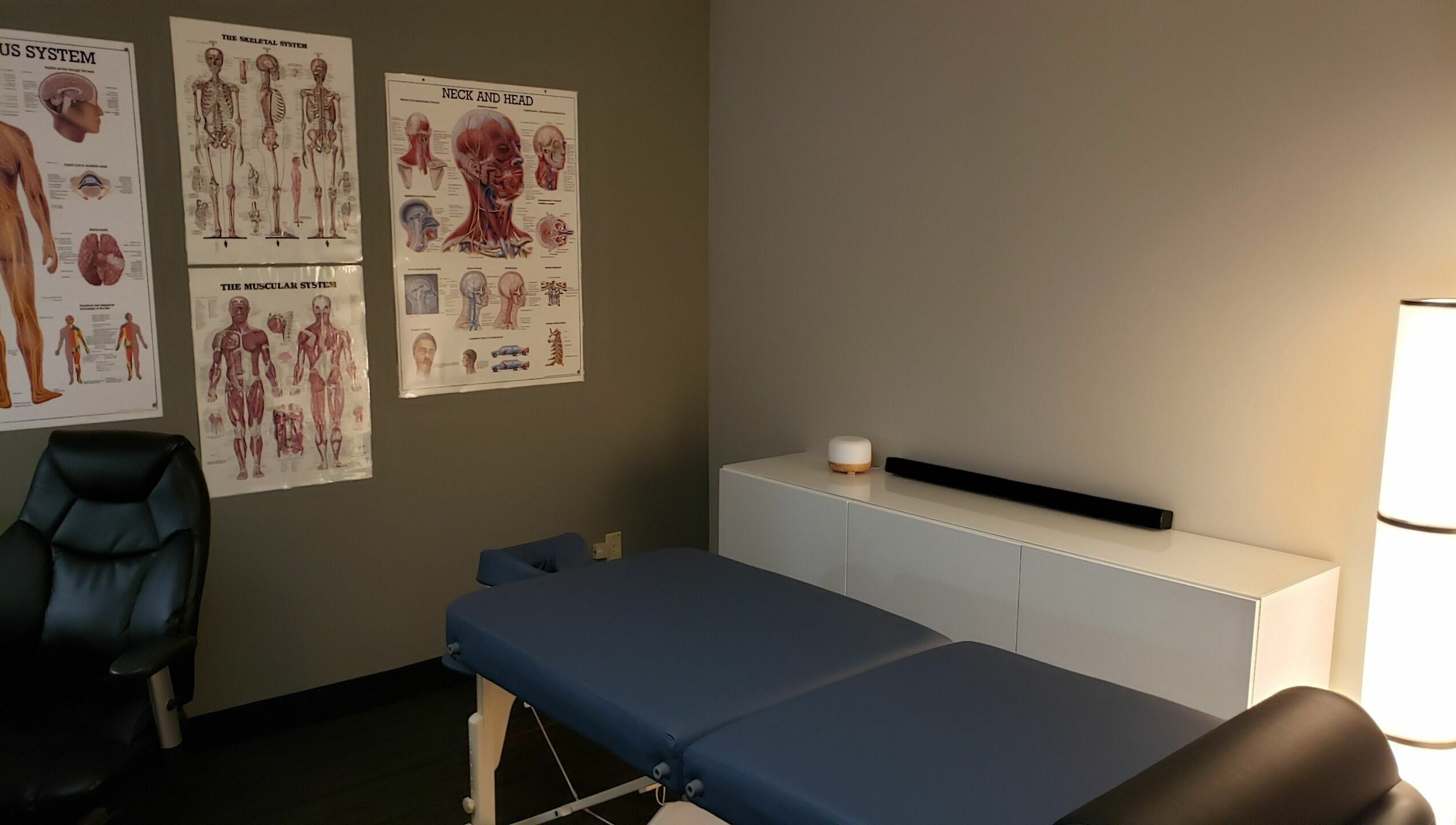 Therapy room at Piotr Gorecki Manual Therapy Clinic Inc., Calgary, Alberta, CA with anatomical charts and massage table.