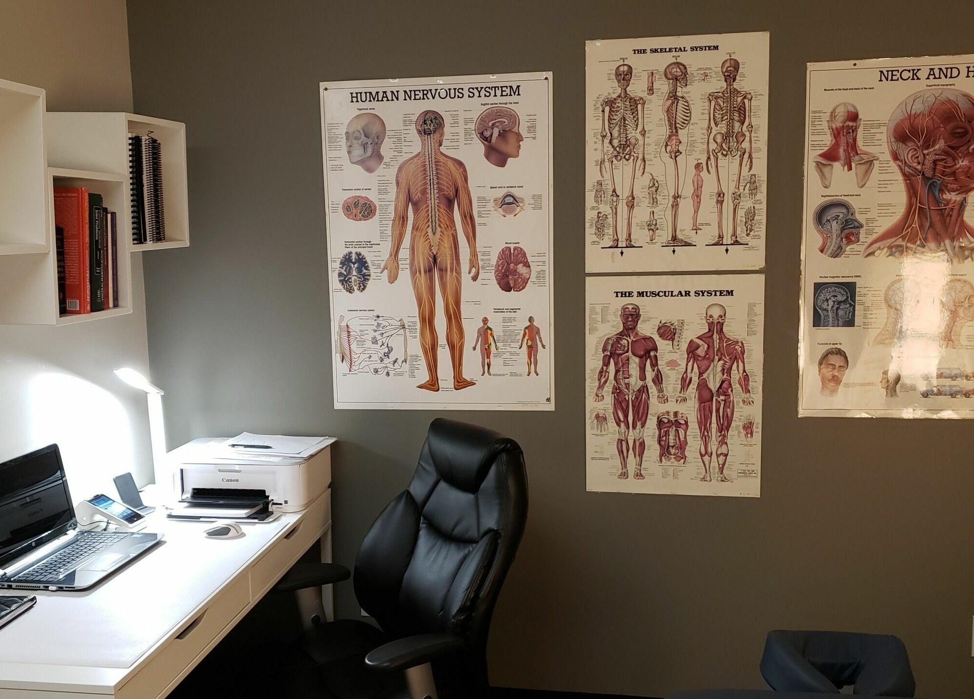Cozy therapy office at Piotr Gorecki Manual Therapy Clinic Inc., Calgary, Alberta, CA, featuring anatomical charts.